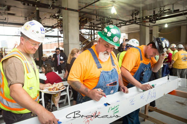 Workers signing the beam at One Theater Square